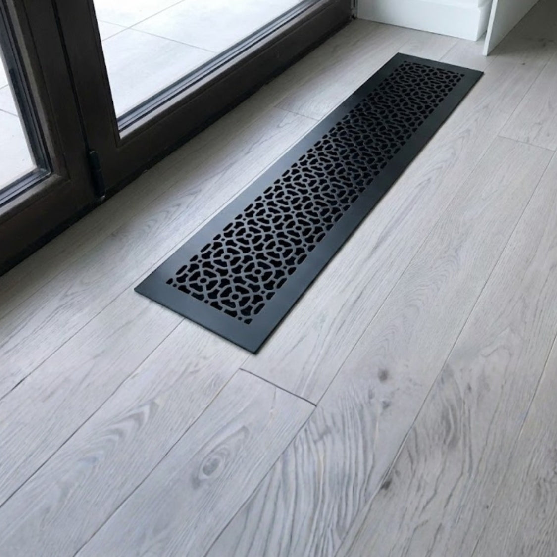 Achtek 6x30 air return vent shown in powder coated black finish and geometric pattern, provided with color matching screws
